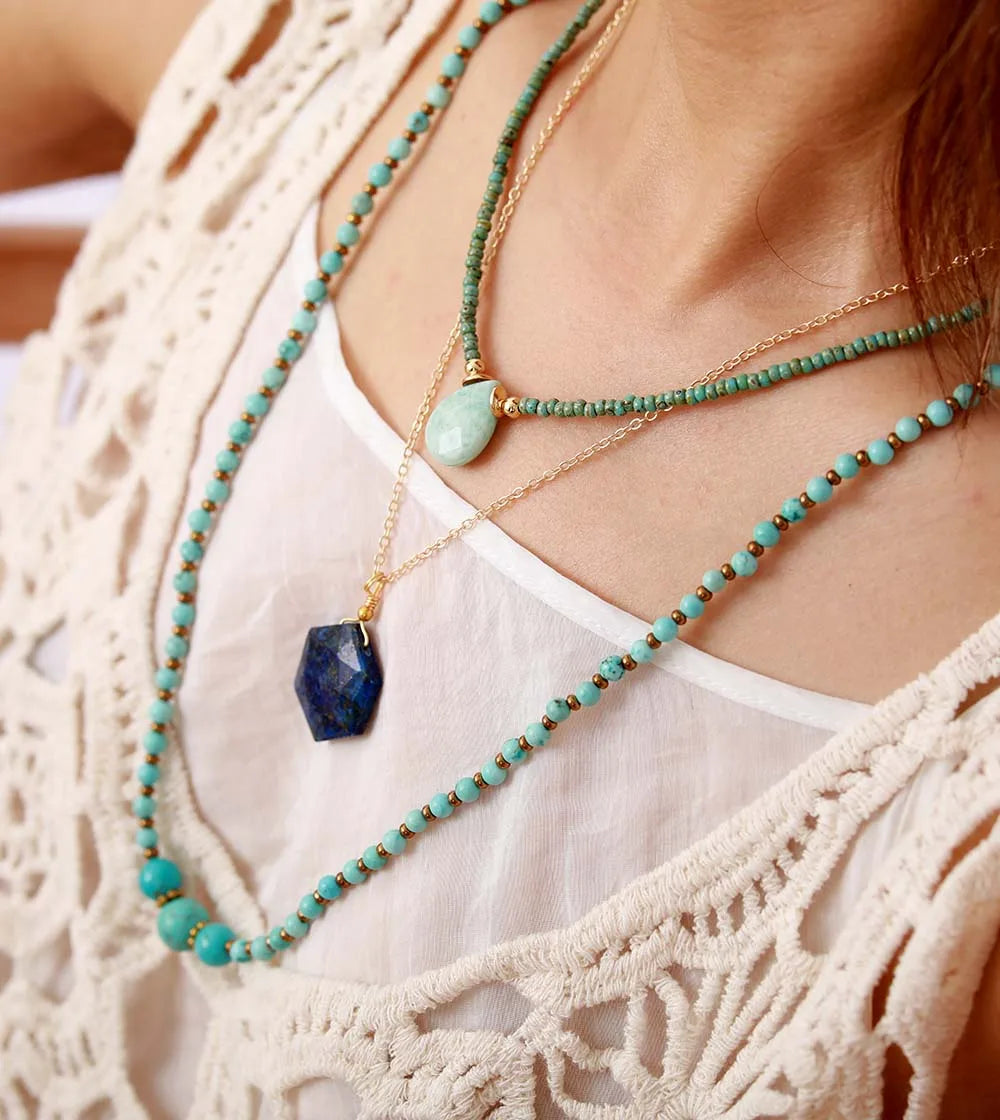 woman wearing boho style layered gold necklaces  woman wearing boho style layered gold necklaces