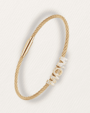 Gold bracelet with pearl-like beads on a light gray background