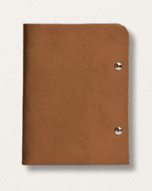 Brown leather notebook with metal rivets on a light gray background