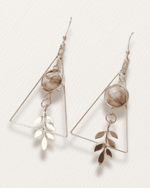 Pair of earrings with geometric designs and leaf-like elements on a light background