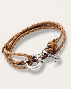 Brown braided leather bracelet with a silver anchor clasp on a light beige background