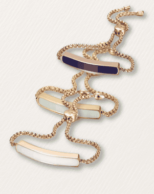 Gold necklace with blue and white pendant on a light gray background