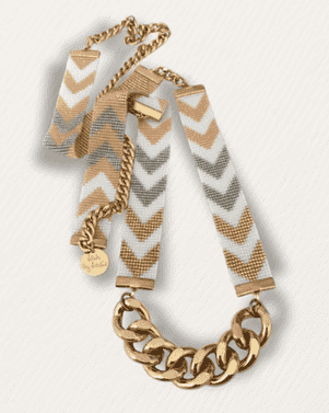 Necklace with gold chain and chevron-patterned fabric pendants on a light background