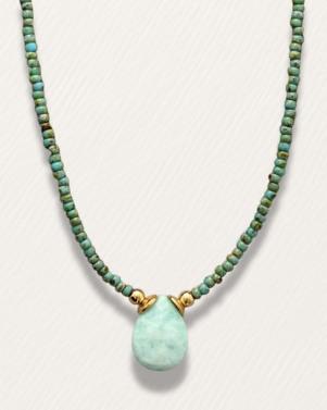 Necklace with green beads and a teardrop pendant on a white background