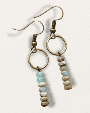Pair of beaded earrings with turquoise and beige beads on a light gray background