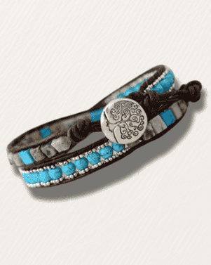 Bracelet with blue beads and tree-of-life charm on a light gray background