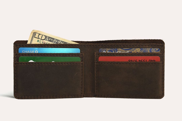 Brown leather wallet with cards and money on a white background