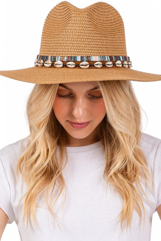 Woman wearing a straw hat with decorative band on a white background