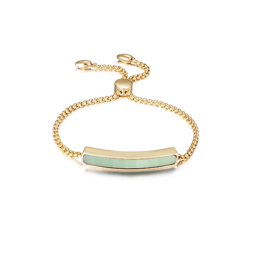 Gold bracelet with a green bar on a white background