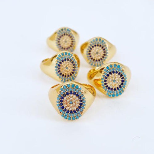 Set of gold rings with blue and black gemstones on a white background