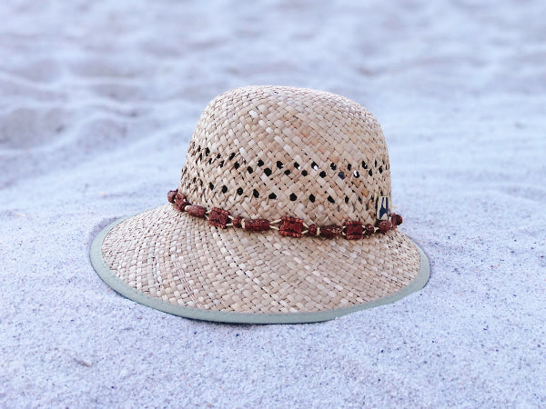 Woven straw hat with a decorative band on a snowy ground