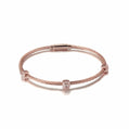 Rose gold bracelet with diamond accents on a white background