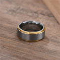 Two-toned ring with gold and black finish on a wooden surface