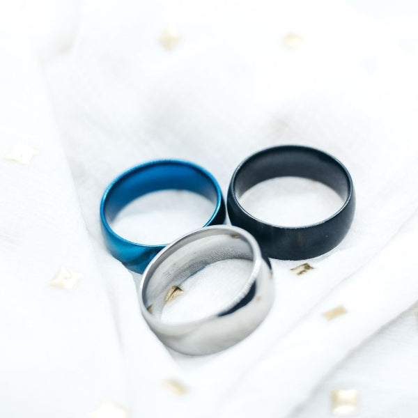 Three rings in blue, silver, and black on a white background