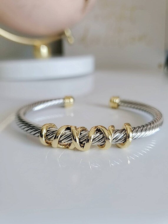 Gold and silver bracelet on a white surface