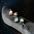 Pair of earrings with colorful galaxy design on a dark background