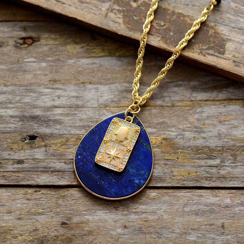 Necklace with a blue pendant and gold chain on a wooden surface