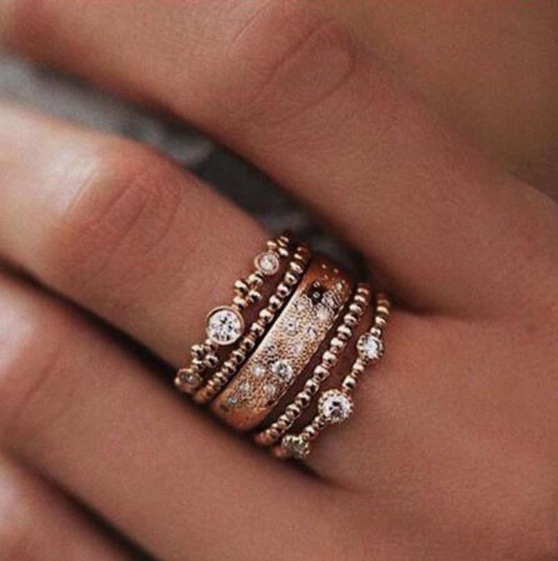 Stack of rose gold rings with diamonds on a hand