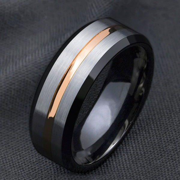 Multicolored ring with rose gold, silver, and black on a textured gray background