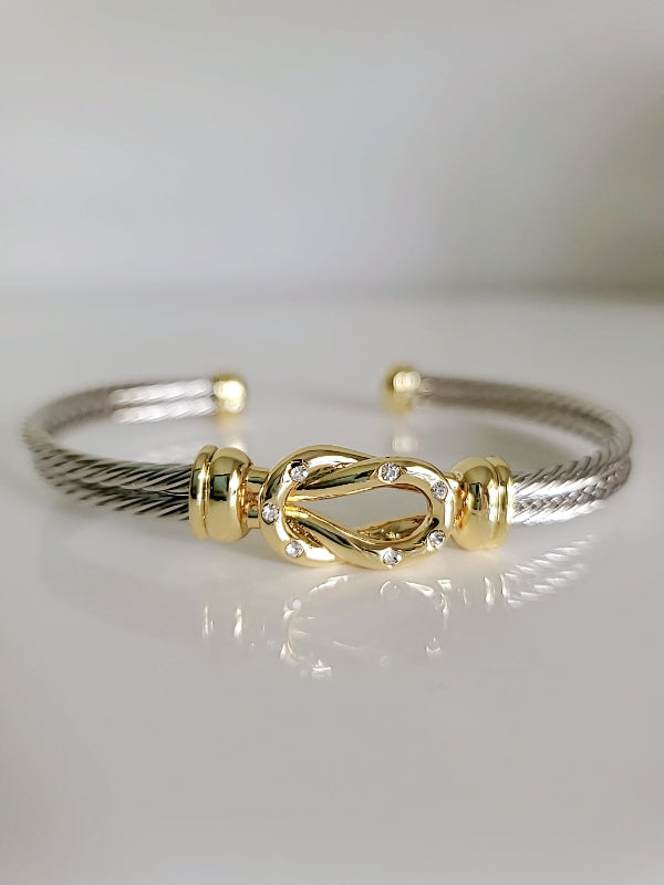 Gold and silver bracelet on a light gray background