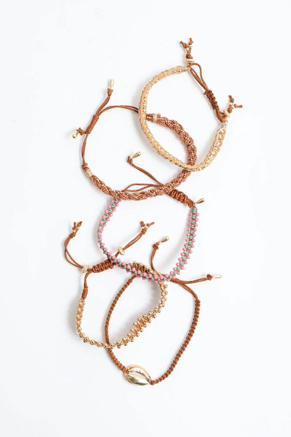 Set of braided bracelets with shell accents on a white background