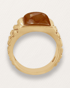 Gold ring with a large brown gemstone on a white background