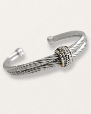 Silver bracelet with a textured design on a white background