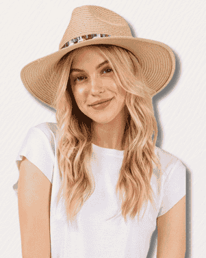 Woman wearing a wide-brimmed hat against a plain background