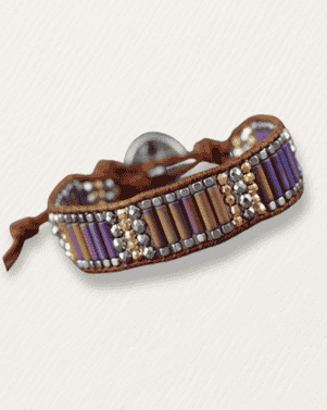 Beaded bracelet with brown leather strap on a light gray background