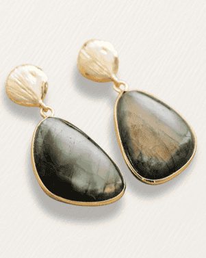 Gold earrings with green stone drops on a light background