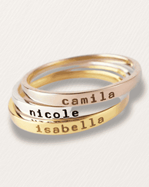 Stack of three name rings with 'Camila', 'nicole', and 'isabella' engraved on a light gray background.