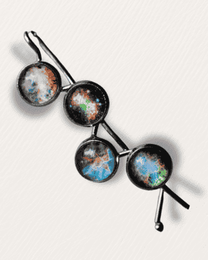 Cosmic-themed hair clips on a light gray background