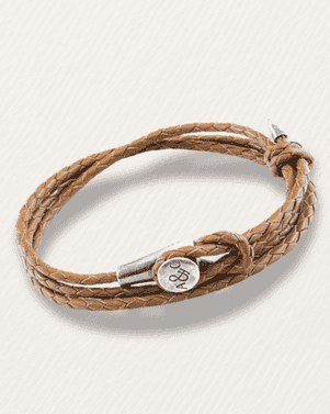 Brown braided leather bracelet with a silver clasp on a light gray background