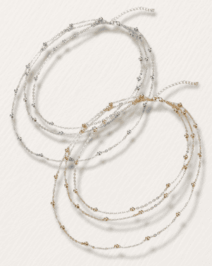 Set of layered necklaces with beads on a white background