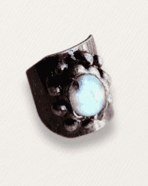 Close-up of a metallic object with a central gemstone on a light gray background