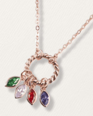 Rose gold necklace with colorful pendant on a light gray background