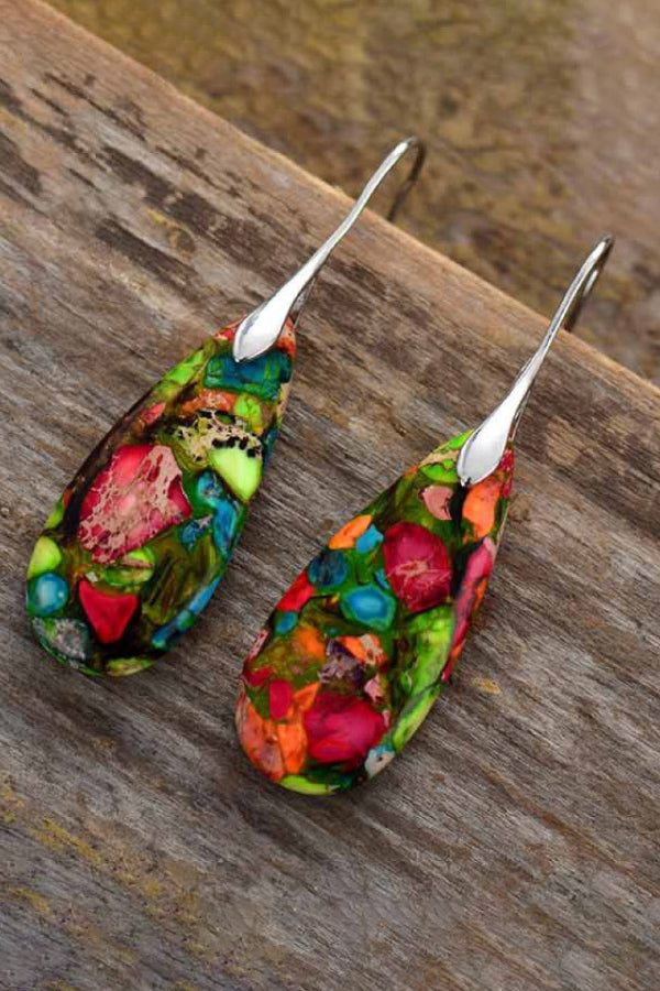 Colorful floral-patterned earrings on a wooden surface
