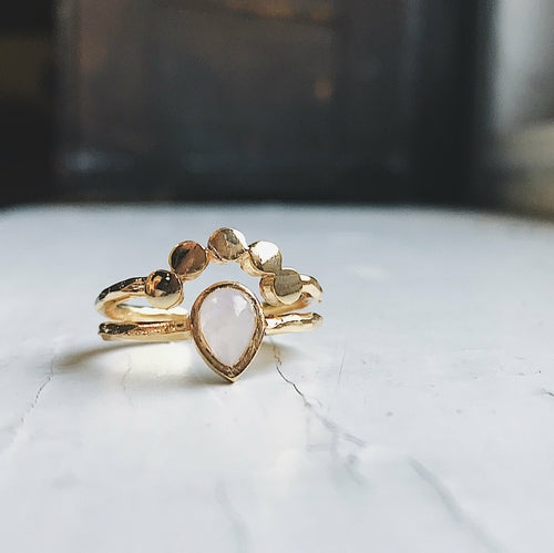 Three gold rings with different designs on a white surface