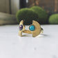 Pair of gold rings with gemstones on a white surface