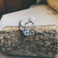 Silver ring with moon and star design on a wooden surface