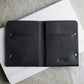 Black leather wallet with 'Kiko' branding on a white surface