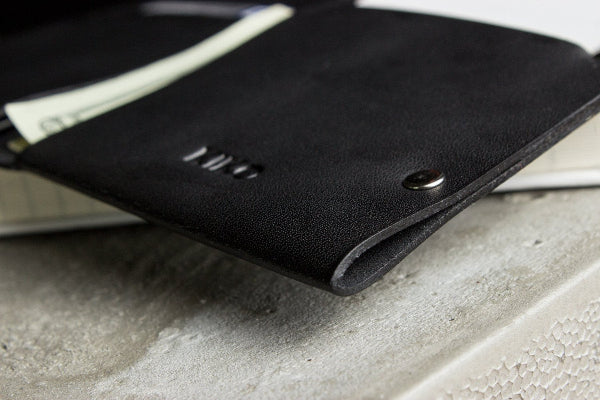 Black leather wallet on a concrete surface