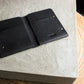 Black leather wallet on a textured stone surface