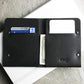 Black leather wallet with cards and money on a light surface