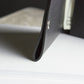 Close-up of a black leather-bound book on white paper