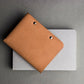 Brown leather wallet on a gray surface