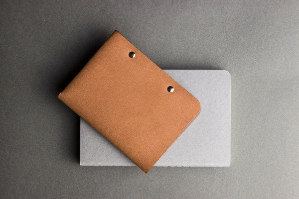 Brown leather wallet on a gray surface
