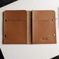 Brown leather wallet with 'Kiko' branding on a white surface with money.