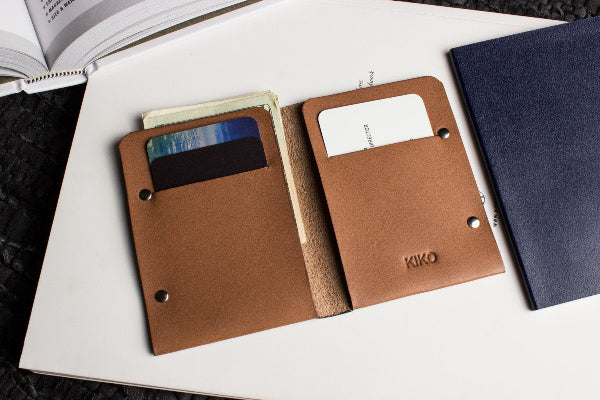 Brown leather wallet with card slots on a white surface, with 'KIKO' branding.