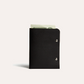 Black leather wallet with money on a white background